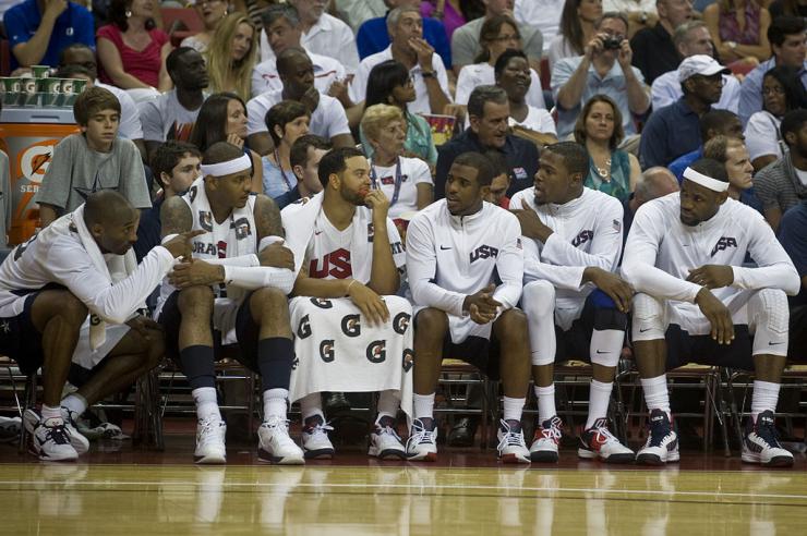 Six basketball players sitting on the bench