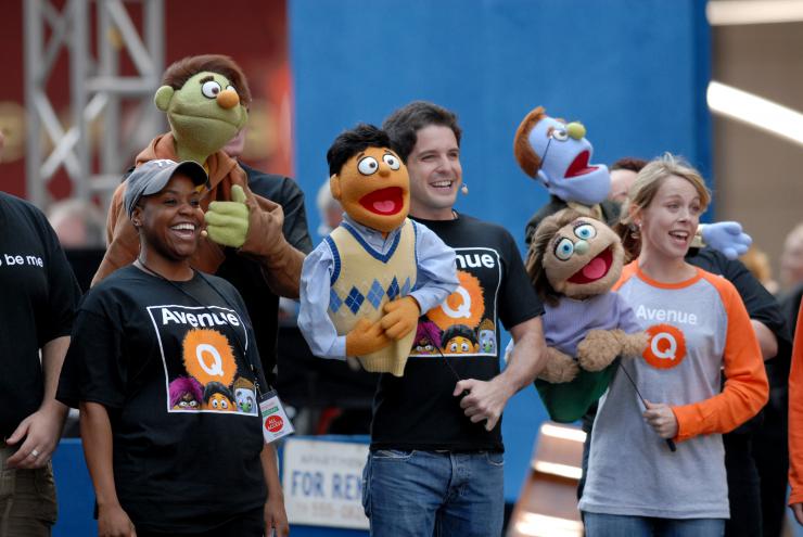 actors with puppets performing at a parade 