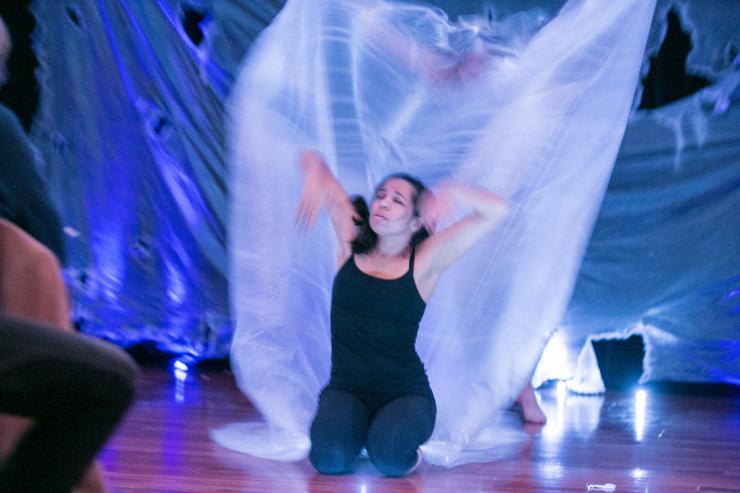 an actress performing in front of a white flowing tarp