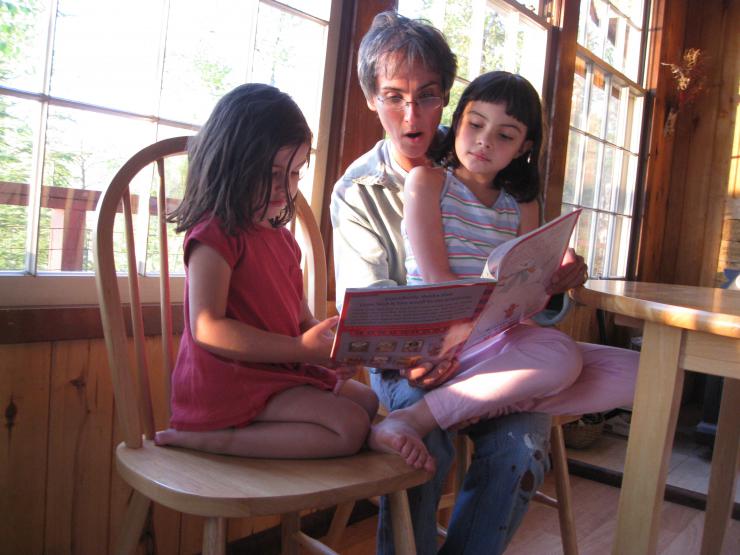 woman reading to two children