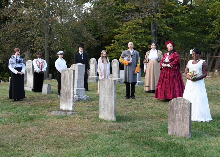actors in costume on a cementary