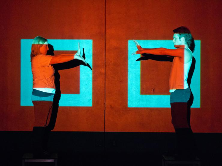 two actors performing in front of light rectangles