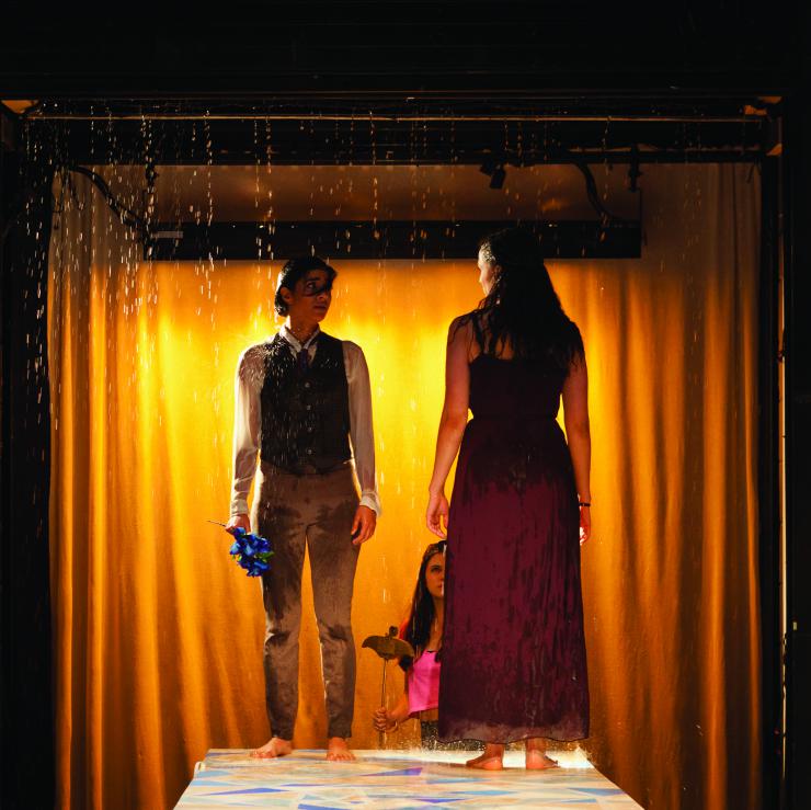 two actors on stage in a "rainshower"