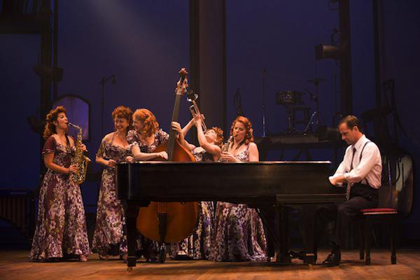 a group of actresses and an actor playing music on stage