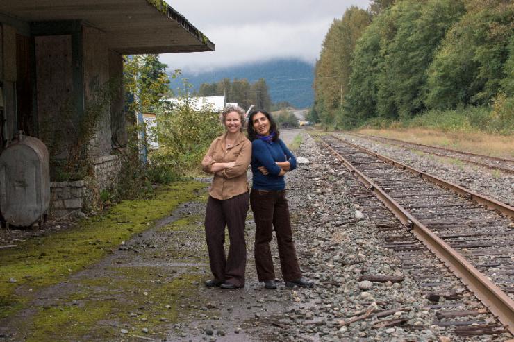 two women posing on train tracks