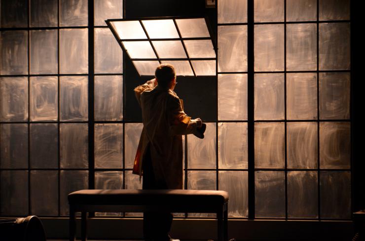 An actor at a window on stage