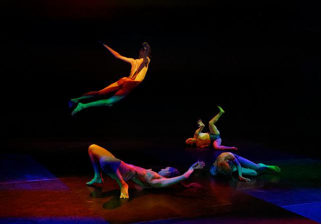 performers dance in colored light