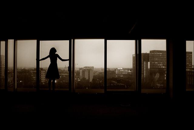 girl silhouetted at a window
