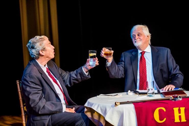 two actors toasting on stage