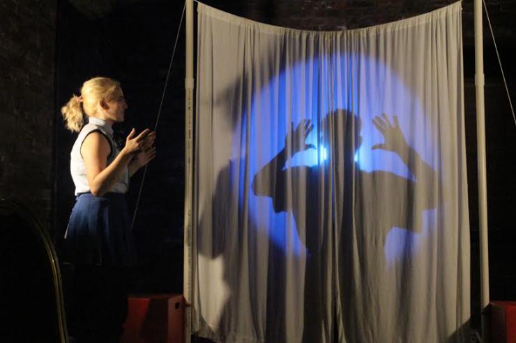 an actress performing in front of a silhoutte