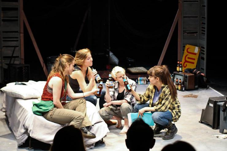 a group of women drinking and talking on stage