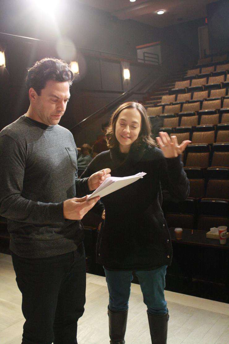 two people holding a script and talking