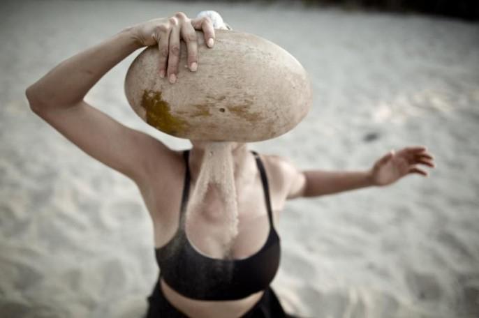 a woman holding a rock up to her face