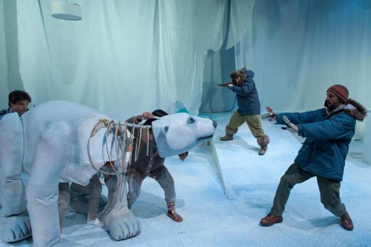 two performers onstage with a polar bear puppet