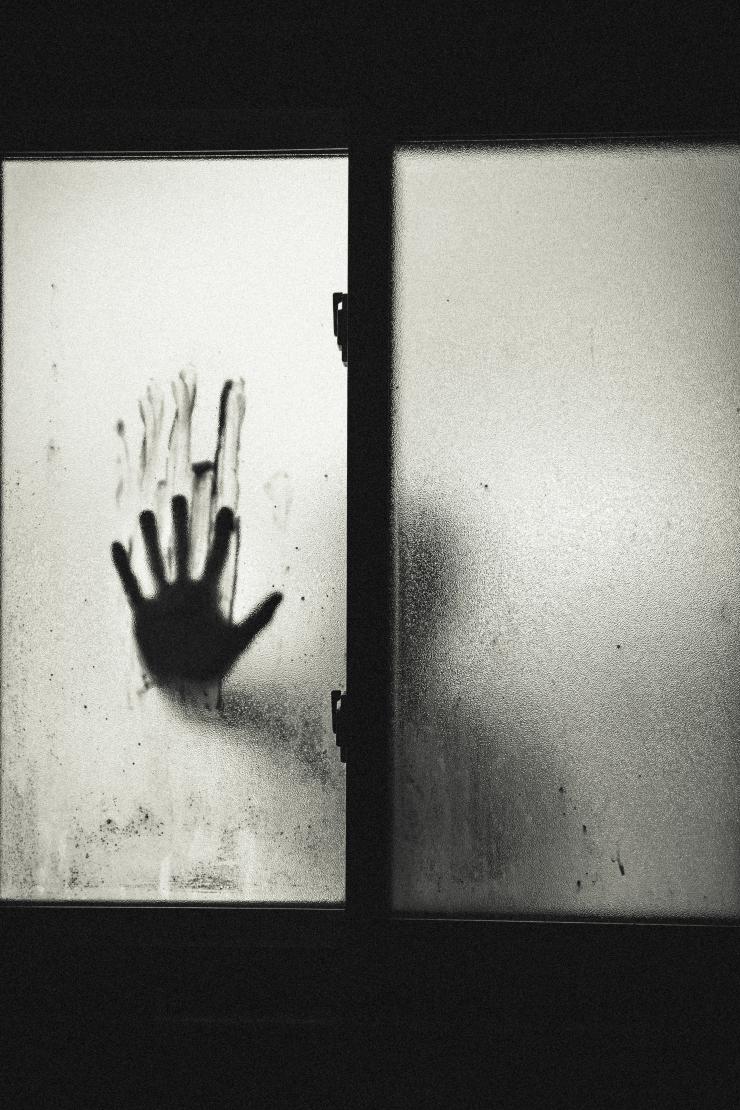 a hand on fogged up glass 