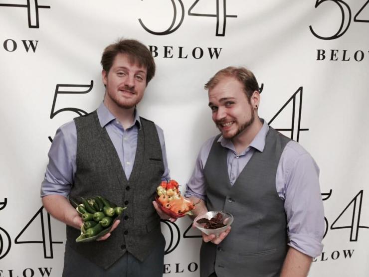 Two men holding peppers 