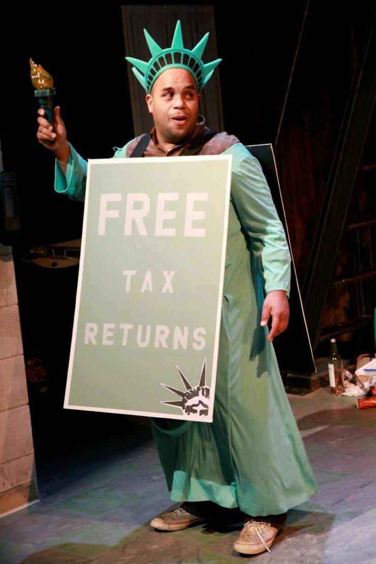 actor dressed as Lady Liberty holding a sandwich board reading: "Free Tax Returns."