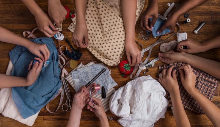 many hands sewing 