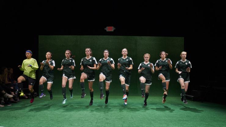 girls jumping in soccer uniforms