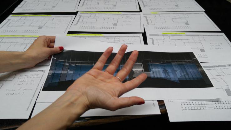 a close up of someone's hands reviewing design sketches