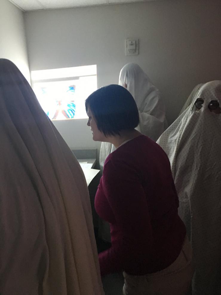 a performer surrounded by people dressed as ghosts