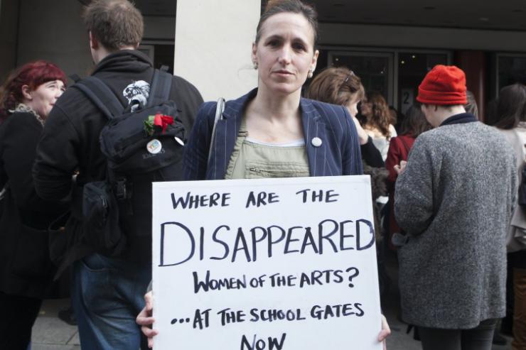 a woman holding a sign 