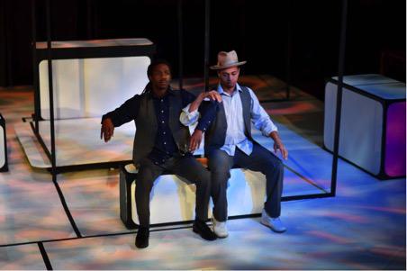 two actors sit onstage