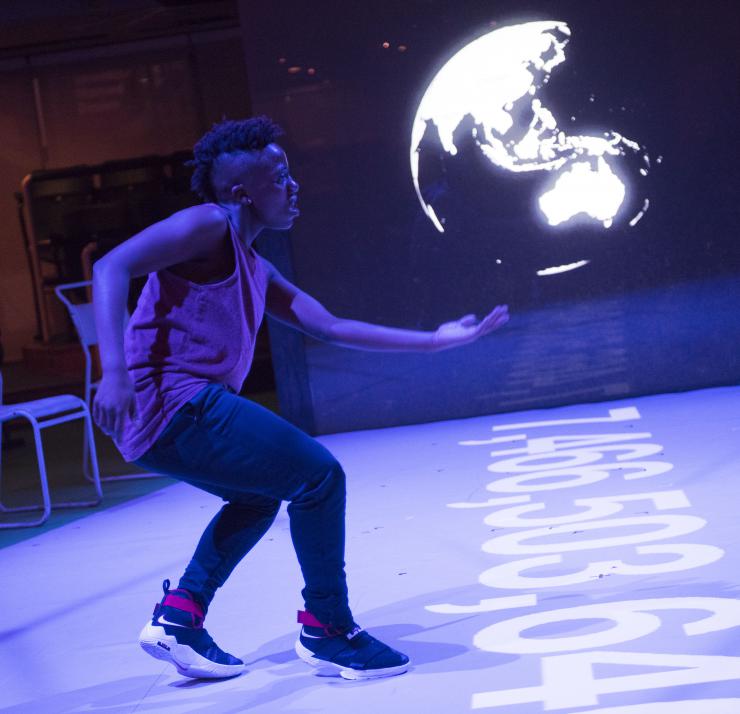 performer in front of projection of a globe