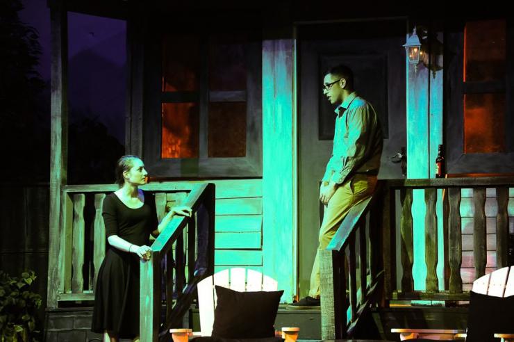 two actors onstage on a porch set