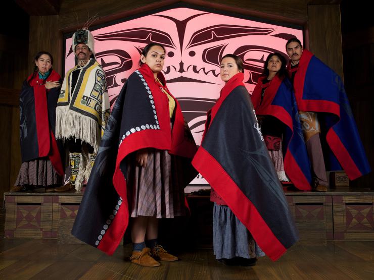 six performers onstage wearing traditional Tlingit garments