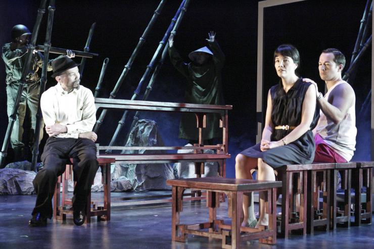 Three actors sitting on stage 