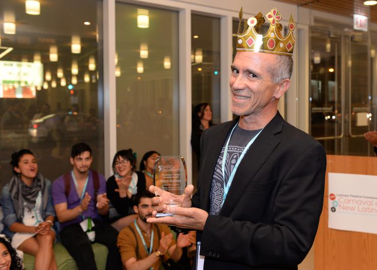 Man holding a reward while wearing a plastic crown