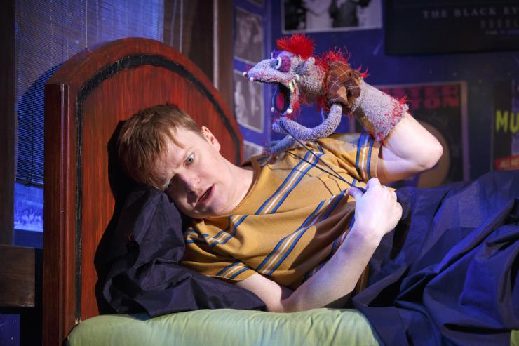 Actor on bed with a hand puppet