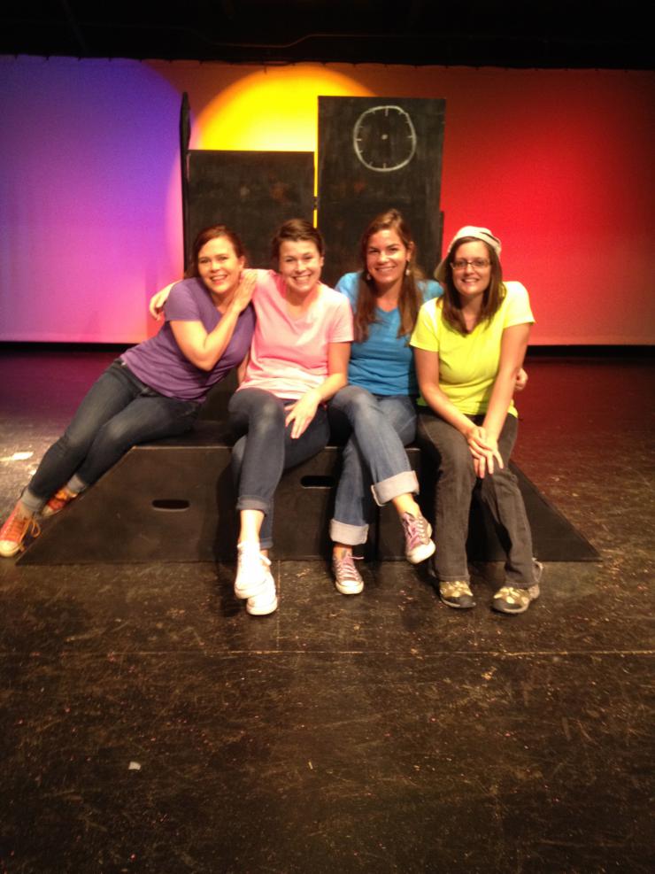 Four women in bright shirts on stage 
