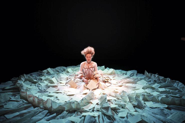 Actor in the center of a circular arrangement of papers