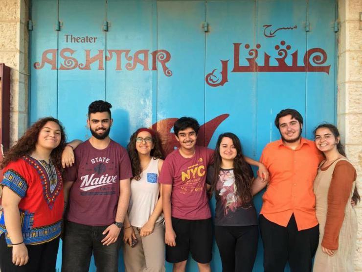 seven youth smile in front of Ashtar Theater