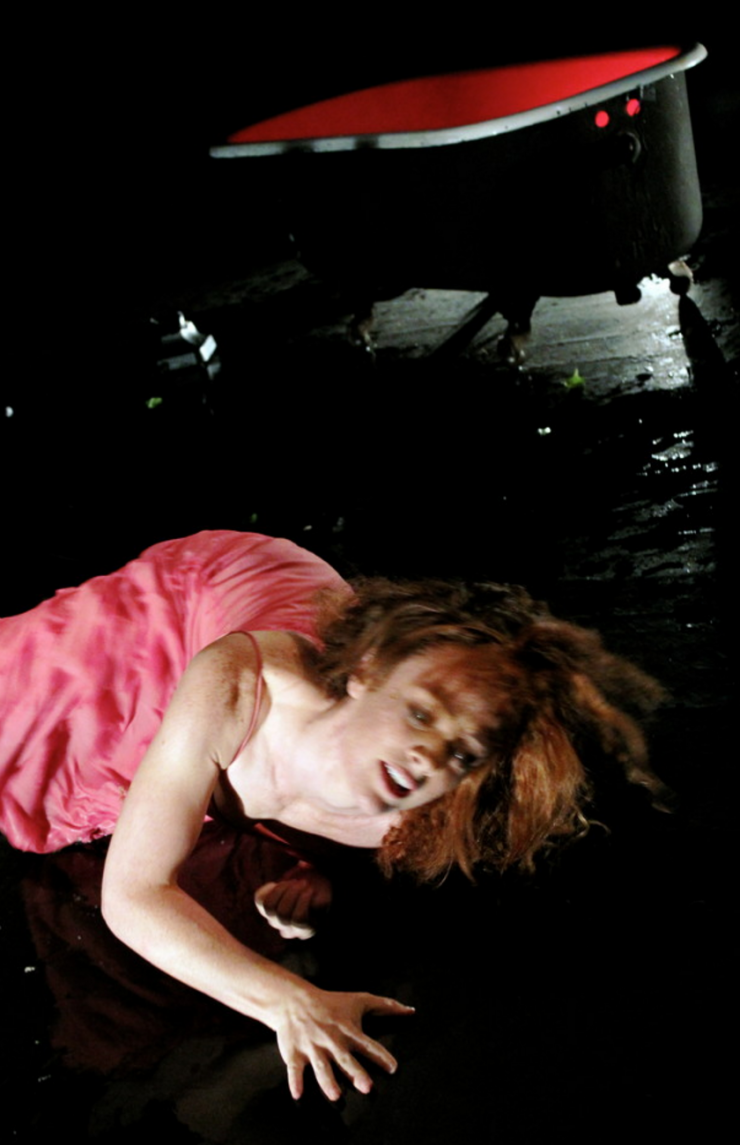 An actor on the floor in a pink dress. 