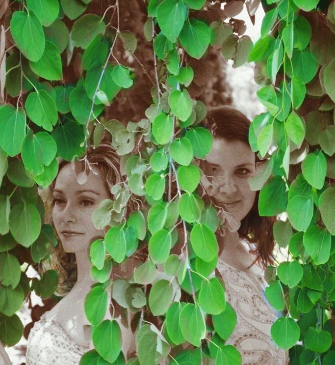 Two women hidden in vines.
