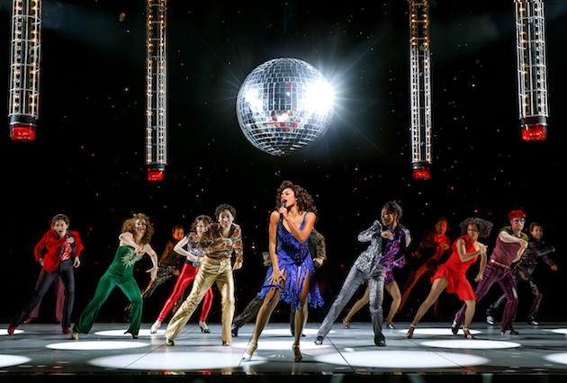 a group of dancers onstage underneath a disco ball