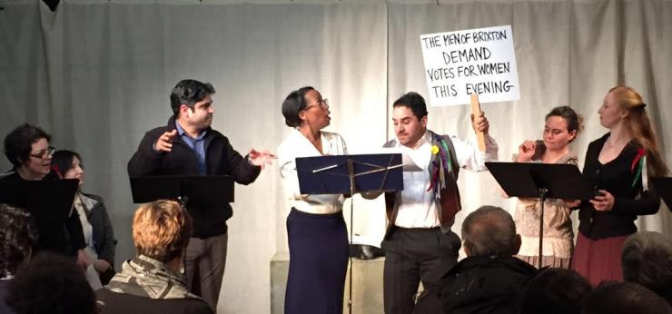 staged reading with actors holding a sign