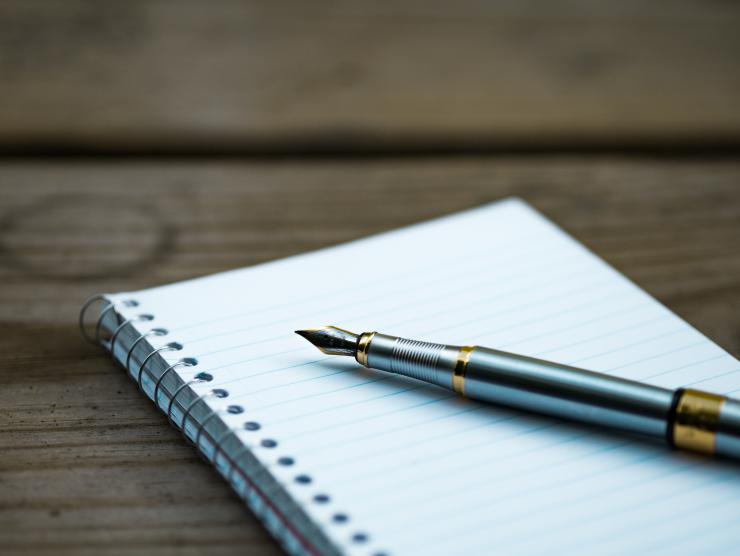 A pen lying on a notebook.