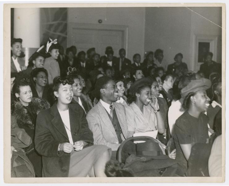 black and white photo of African Americans sitting and smiling