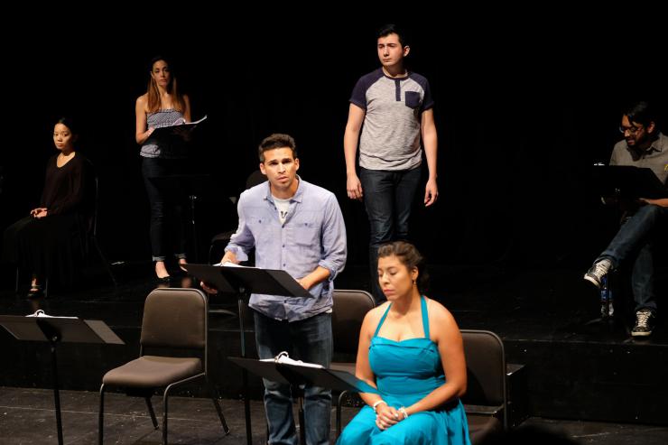 Six actors on stage at music stands.