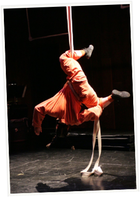 person hanging from an aerial silk