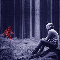 a boy sitting in forest looking at a monster 