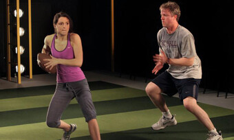 Two actors practice playing football.