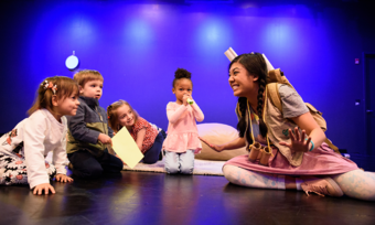 an actor onstage with four young children