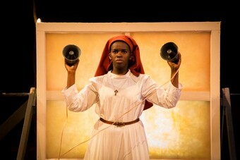 an actor holding two bells