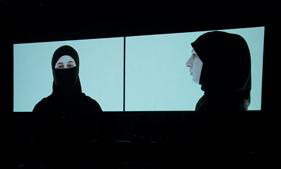 two women projected onto screens