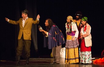 Five actors on stage dressed in Roma clothes from the 1940's.
